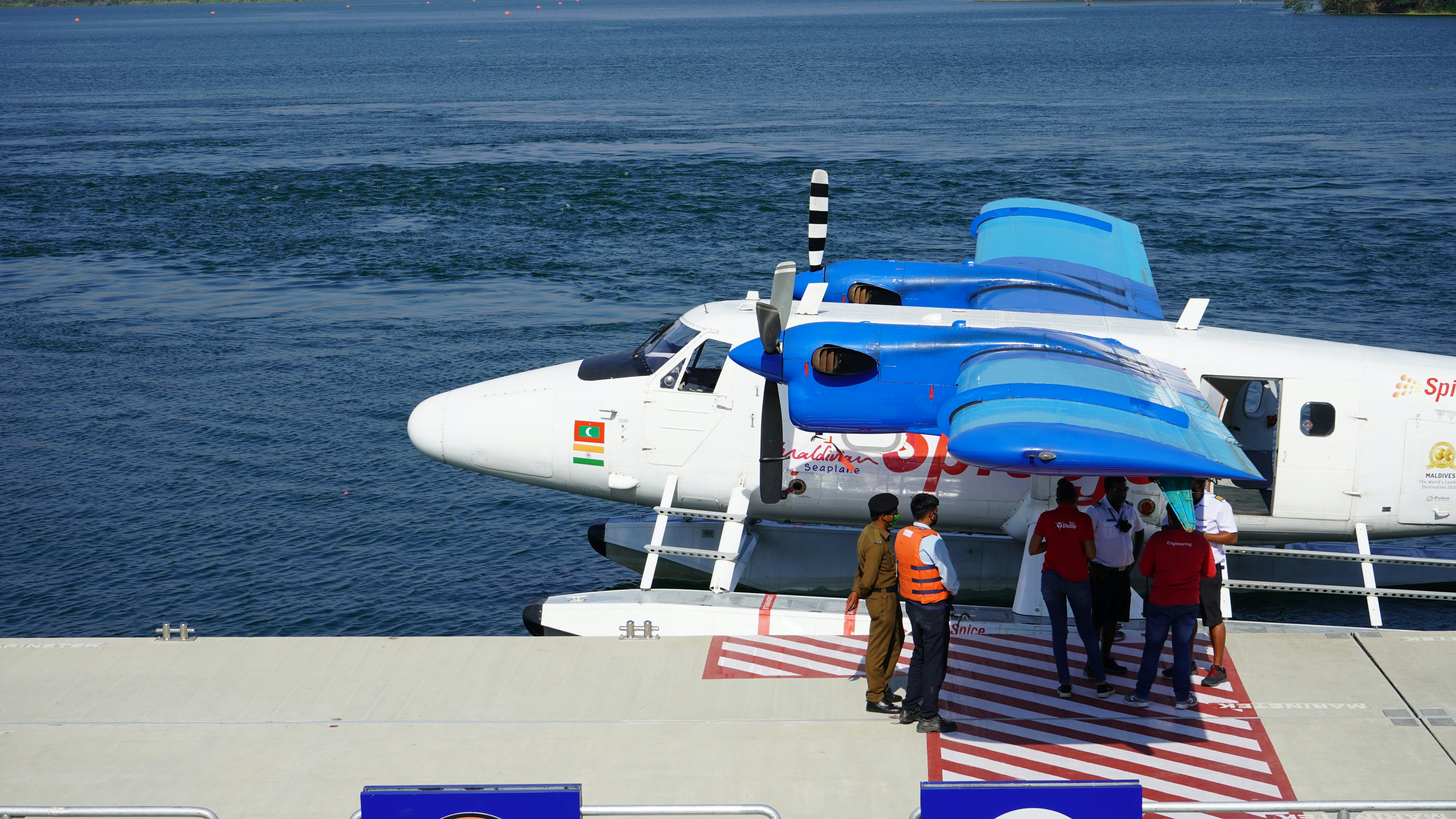 people walking on the dock near white and blue airplane during daytime, Seaplane in a riverfront