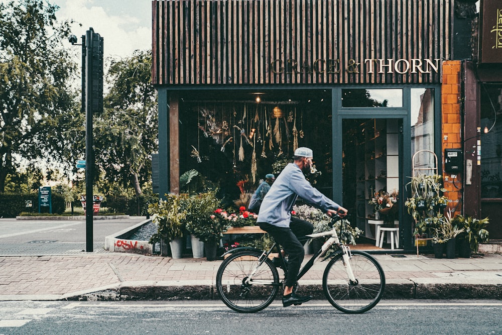 man in gray jacket riding on black bicycle during daytime