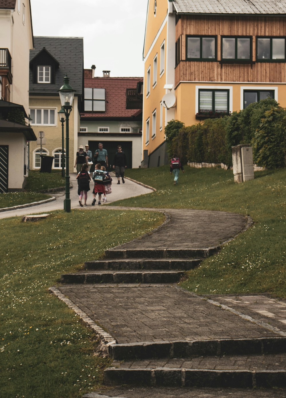 personnes marchant sur un champ d’herbe verte près d’un bâtiment en béton brun pendant la journée