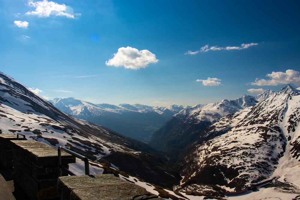 white clouds over snow covered mountains