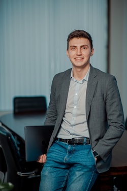 man in gray suit jacket smiling
