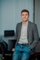 man in gray suit jacket smiling