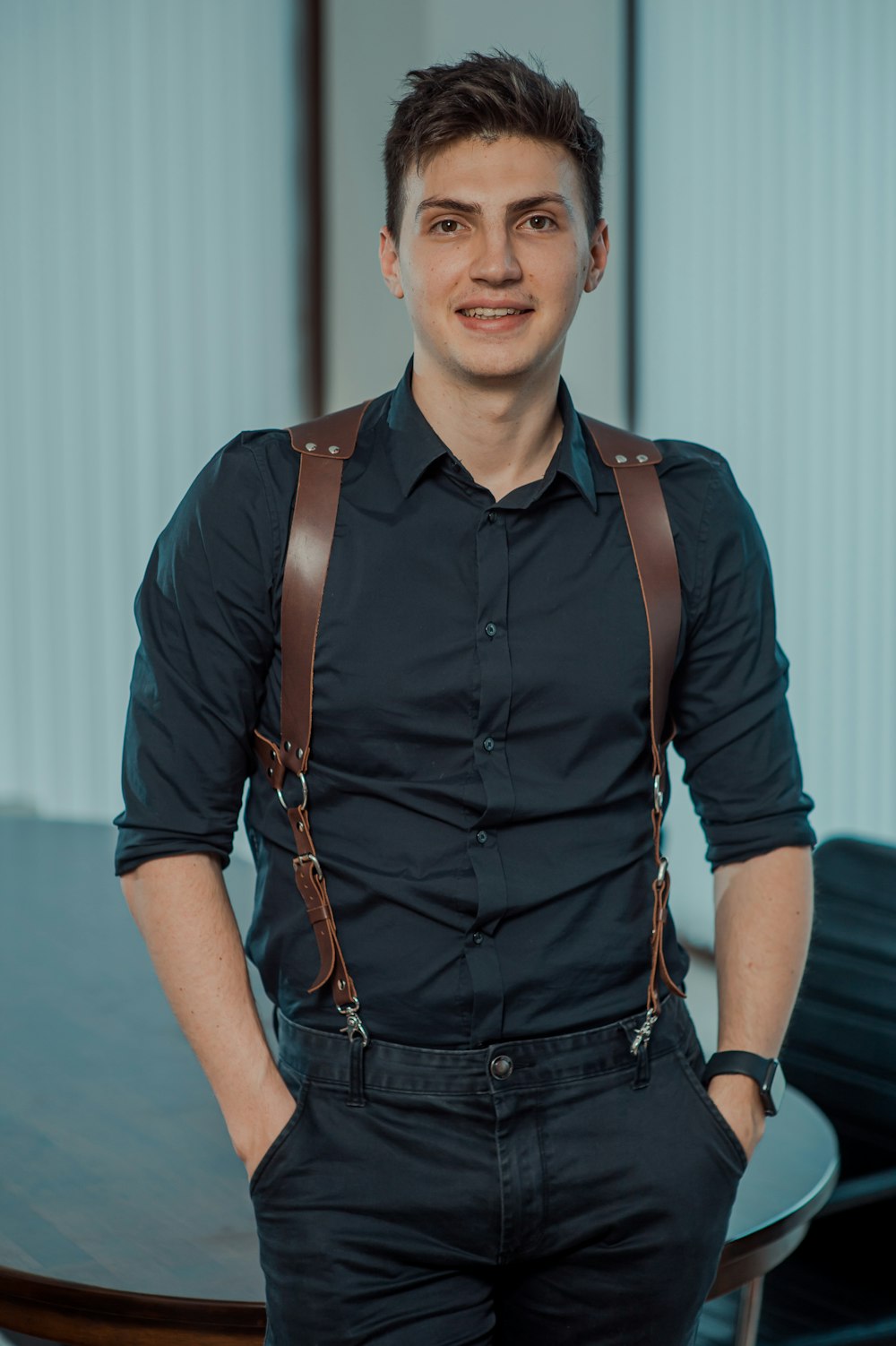 man in blue dress shirt and black denim vest