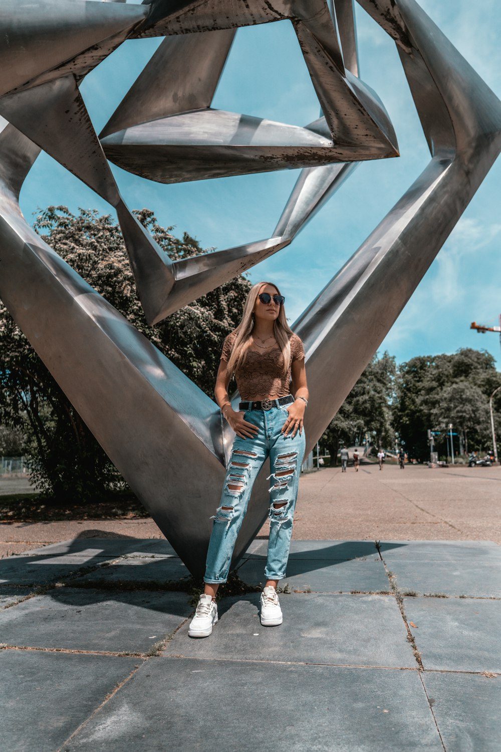 woman in blue denim jeans standing on brown concrete floor during daytime