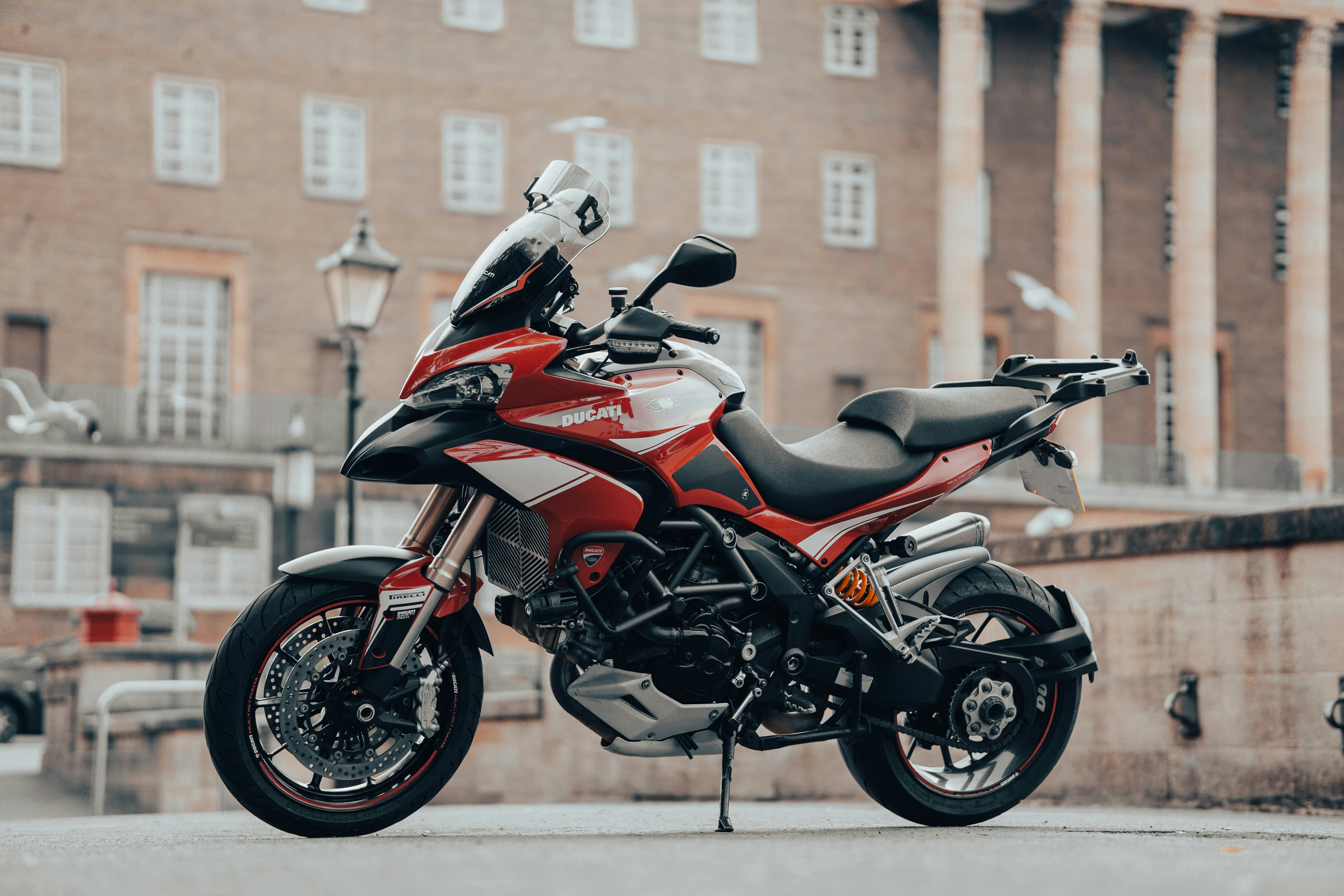 red and black sports bike parked on the street