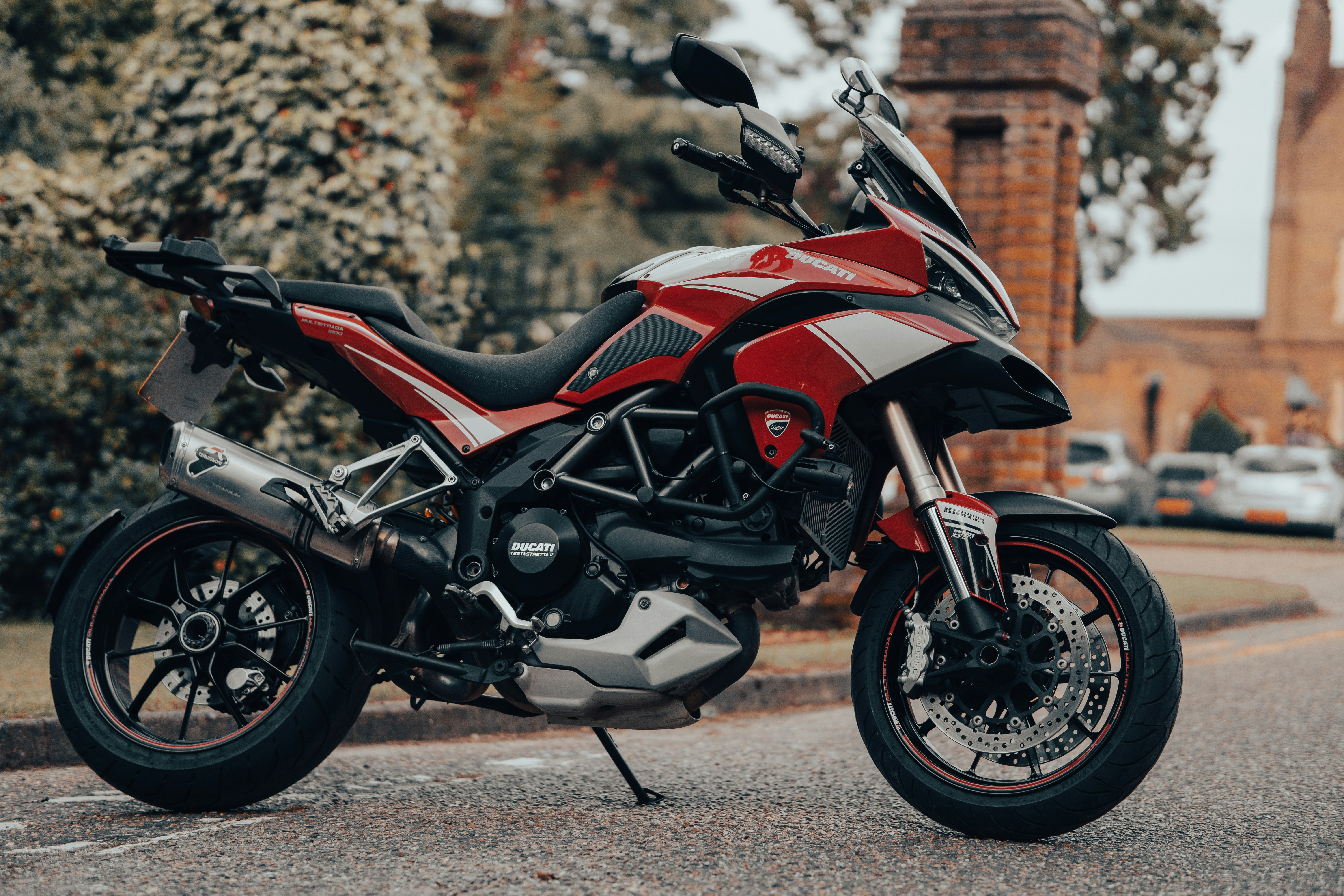 red and black sports bike parked on road during daytime