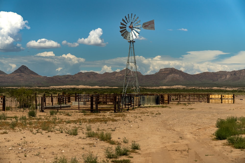 brown wooden windmill on brown field under blue sky during daytime