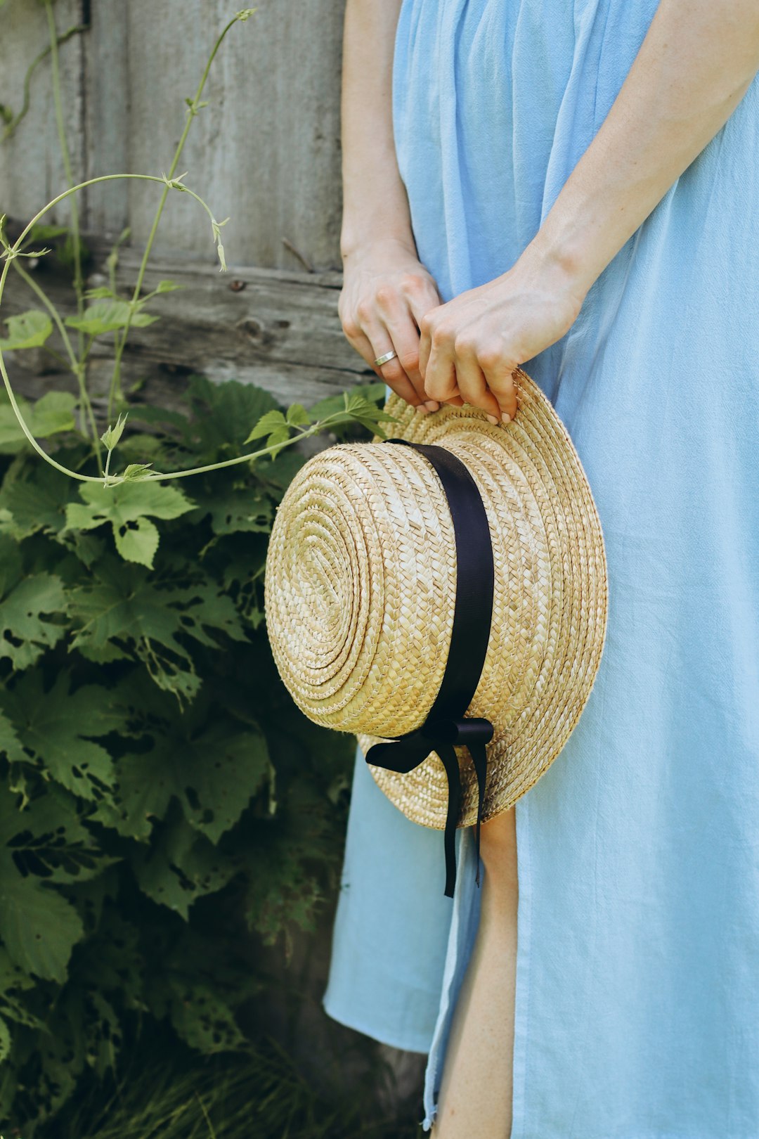 person holding brown woven hat