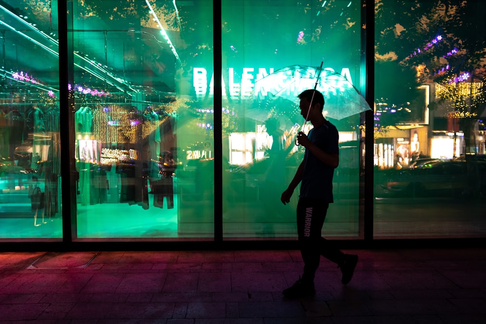 woman in black jacket and black pants standing beside glass wall