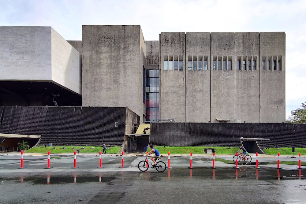 black bicycle parked near gray concrete building during daytime