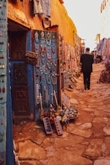 man in black jacket standing in front of blue and white painted wall