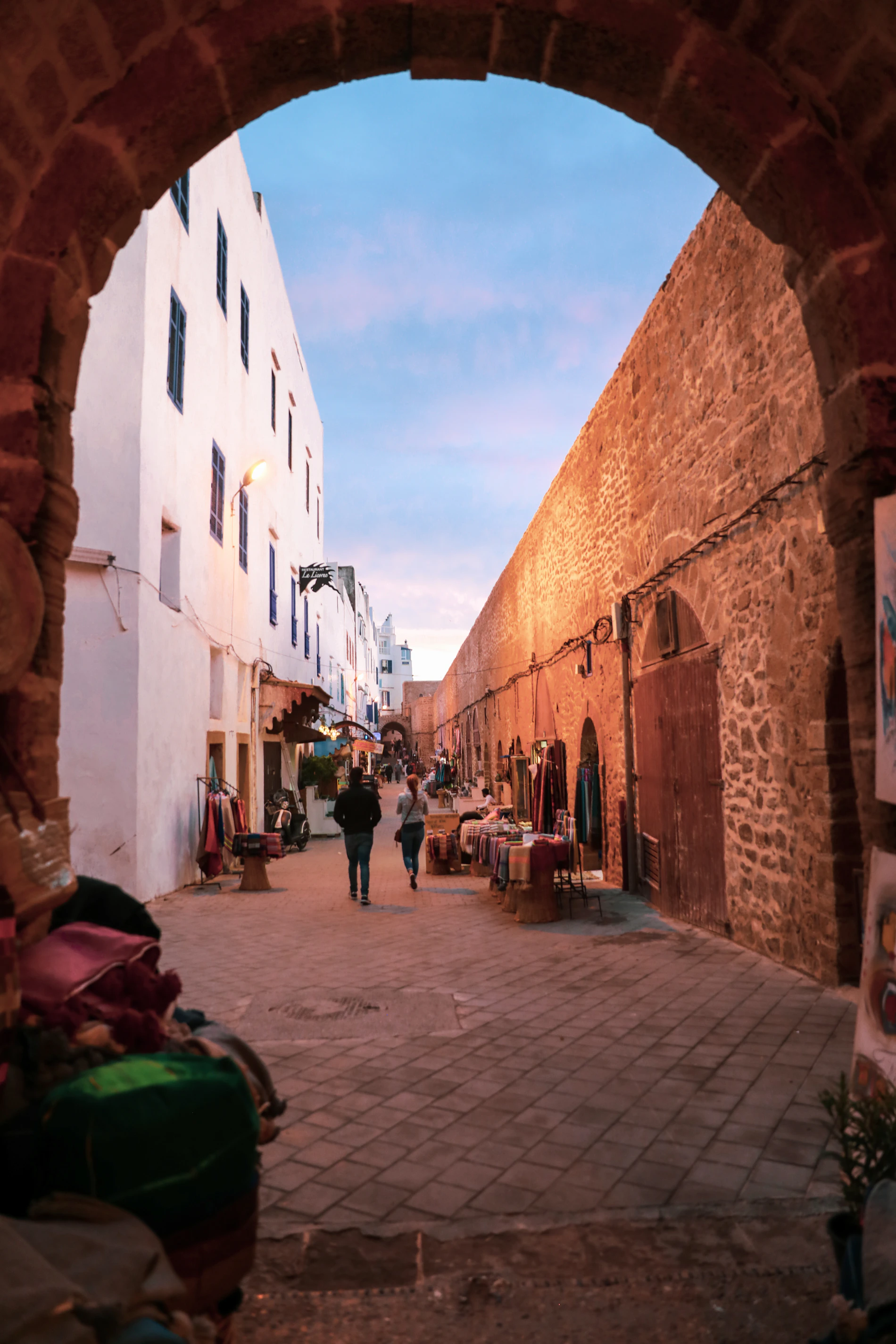 People walking through a historic street in Essaouira medina