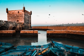 brown brick building near body of water during daytime