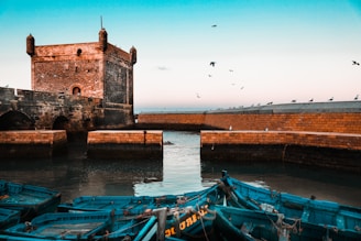 brown brick building near body of water during daytime