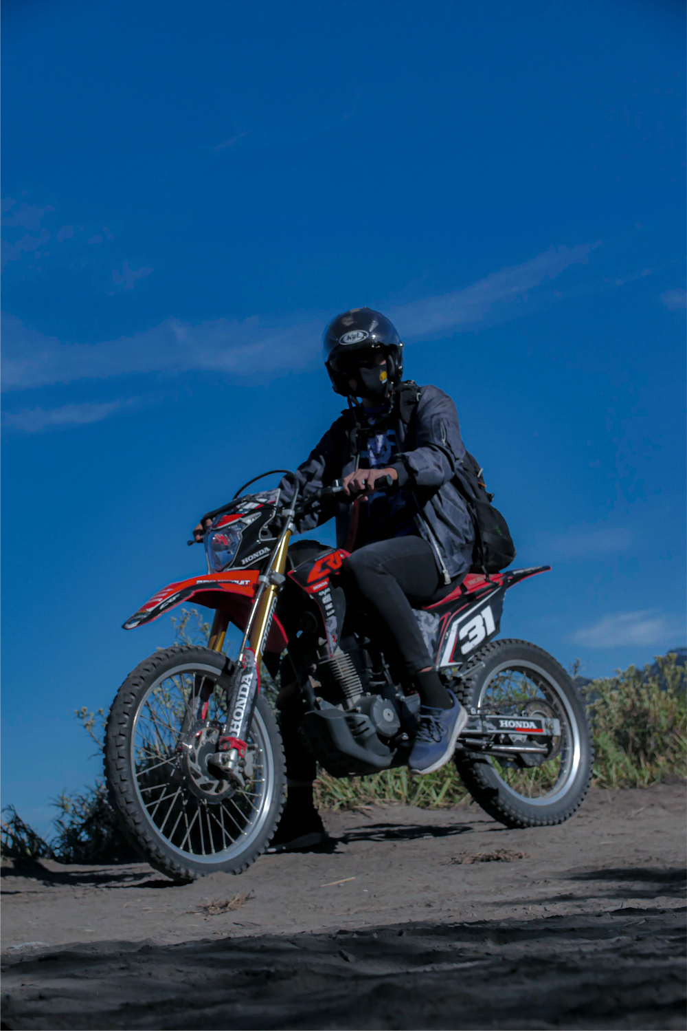 man in black jacket riding red and black motorcycle