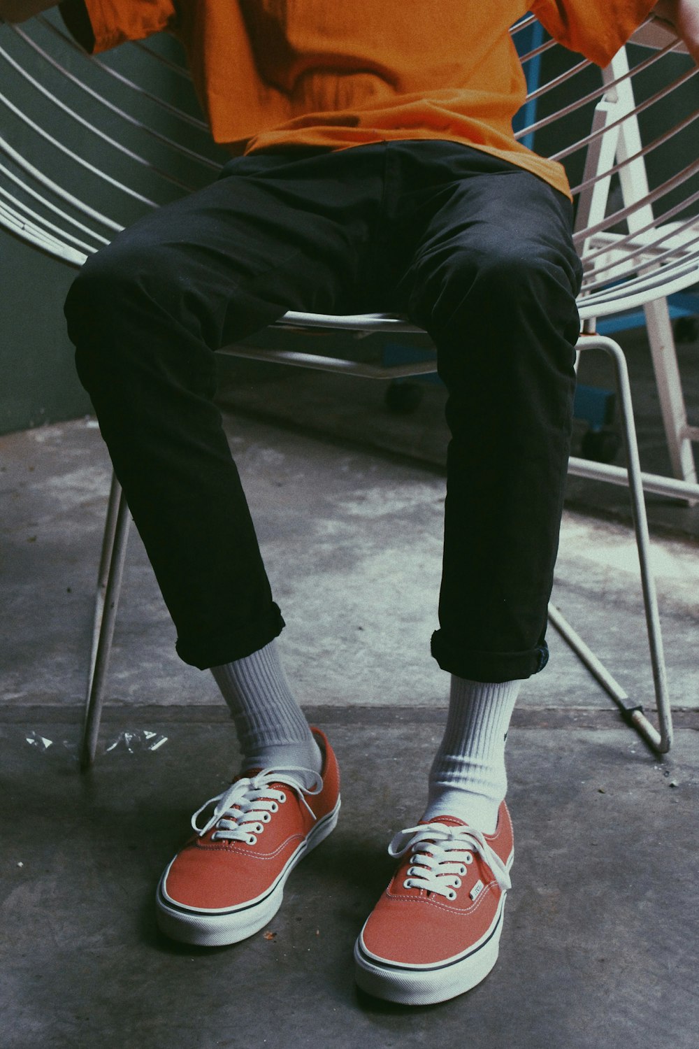 person in black pants and red and white sneakers