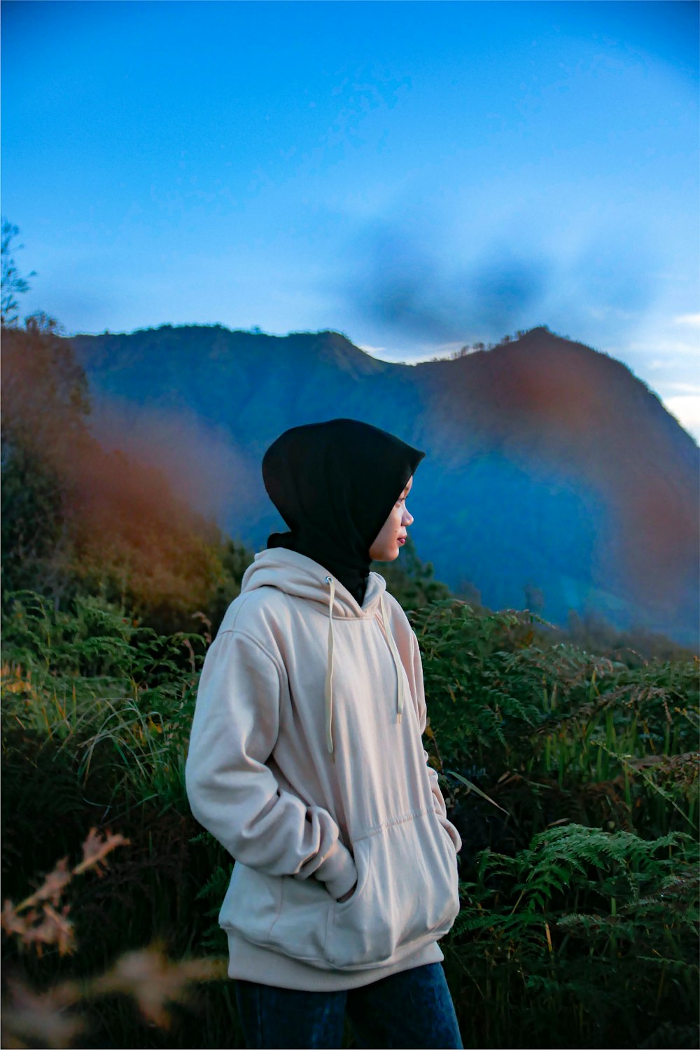 a person wearing a hoodie standing in a field