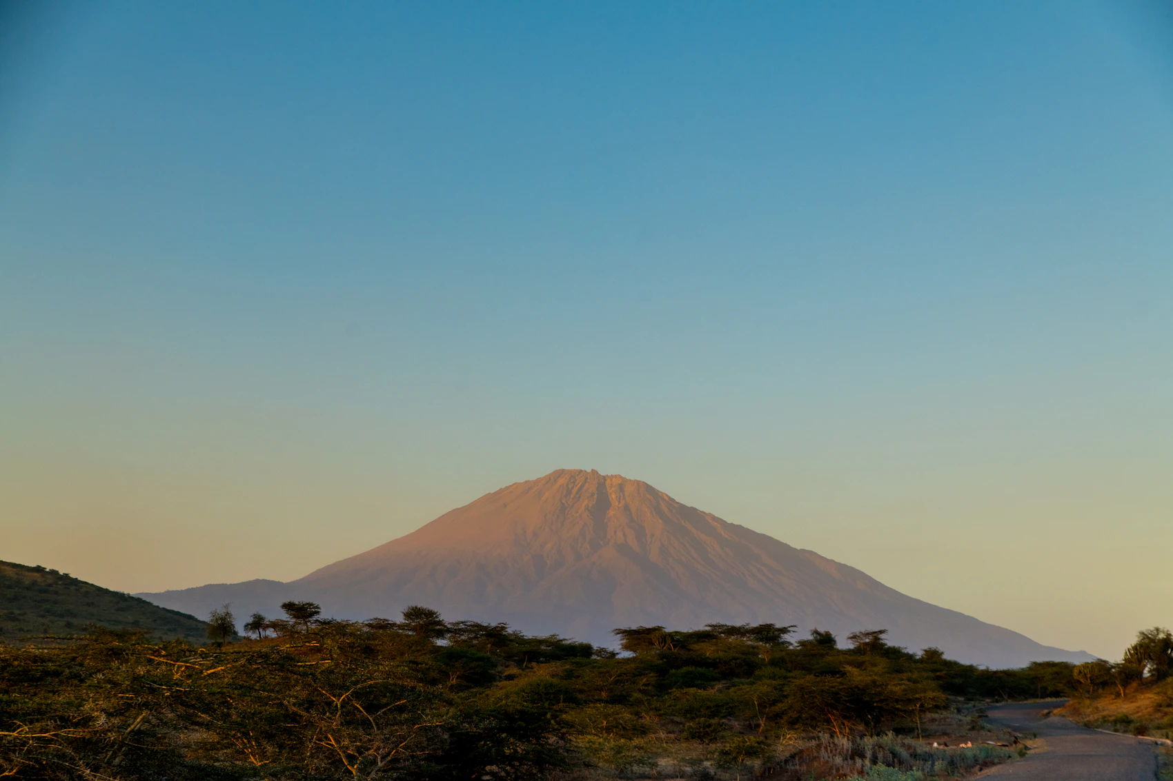 Mount Meru rising beneath a clear blue sky near Arusha