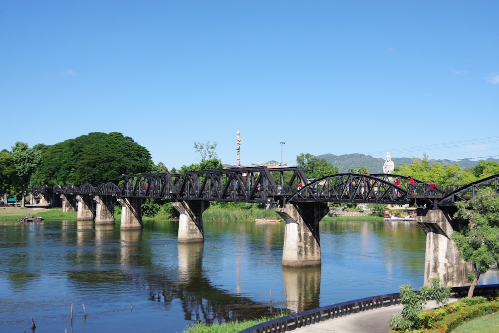 Graue Betonbrücke über den Fluss unter blauem Himmel tagsüber