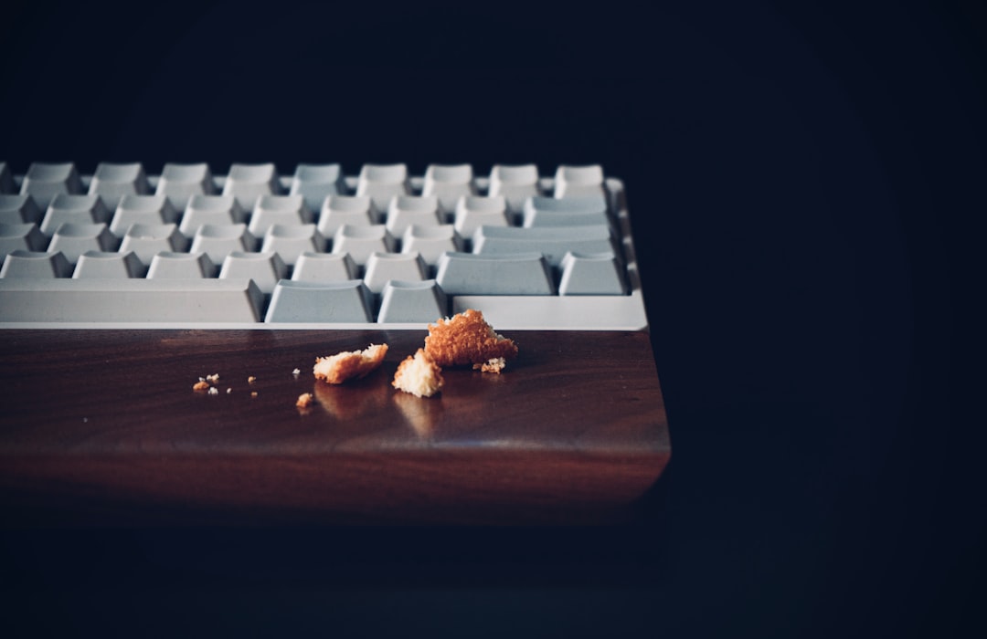 white computer keyboard on brown wooden desk