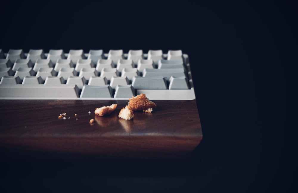 white computer keyboard on brown wooden desk