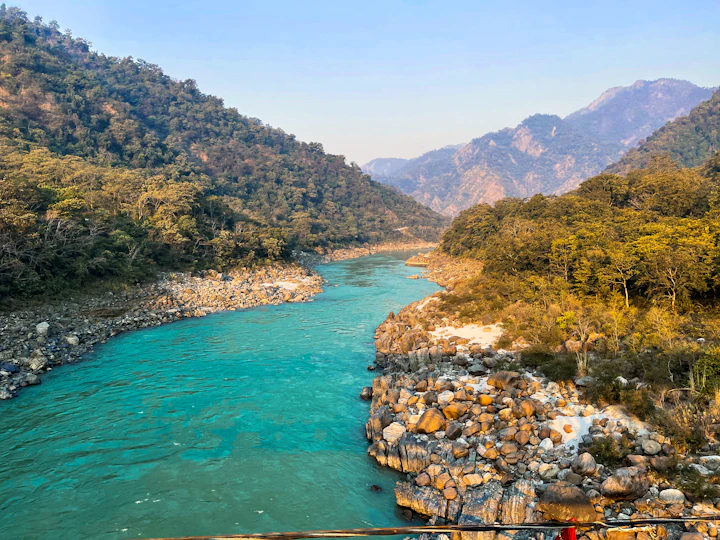 A turquoise river running through a rocky, forested canyon