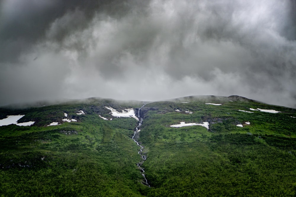 green grass field under white clouds