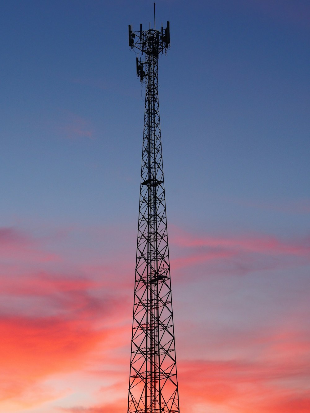 black metal tower under orange and blue sky