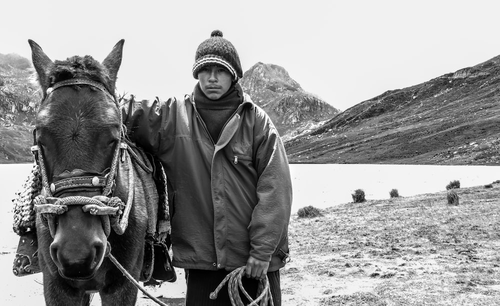grayscale photo of man riding horse