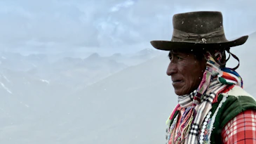 man in white red and blue plaid shirt wearing brown hat