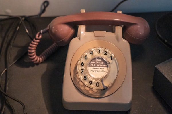 A beige corded rotary phone