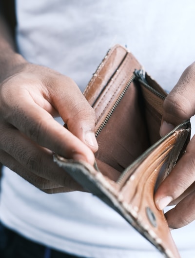 person holding brown leather bifold wallet