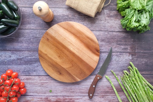 brown wooden chopping board beside green vegetable