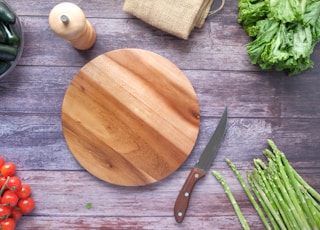 brown wooden chopping board beside green vegetable