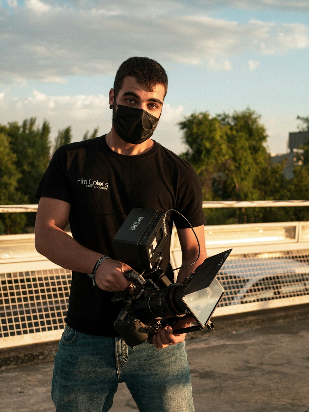 man in black crew neck t-shirt and blue denim jeans holding black dslr camera