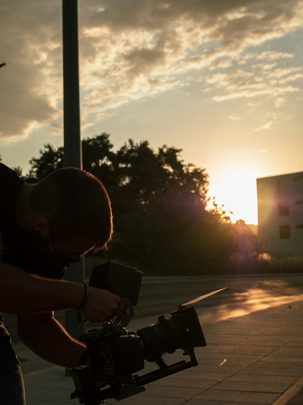 man in white t-shirt sitting on bench during sunset