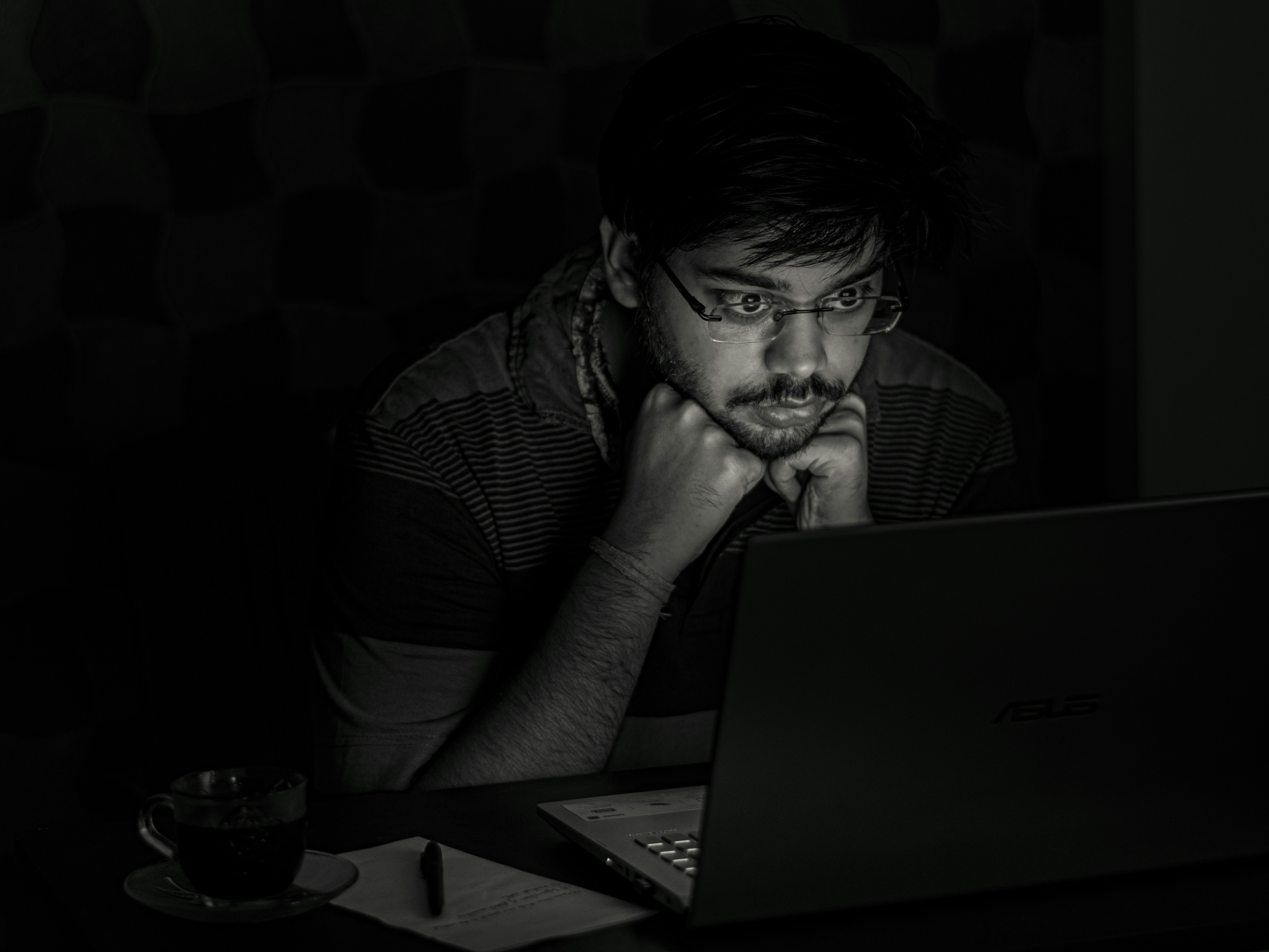 man in black and white striped shirt using black laptop computer