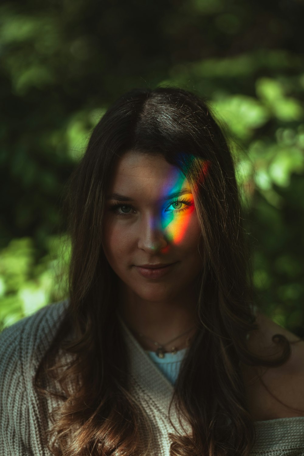 woman in gray knit cardigan with green blue and orange face paint