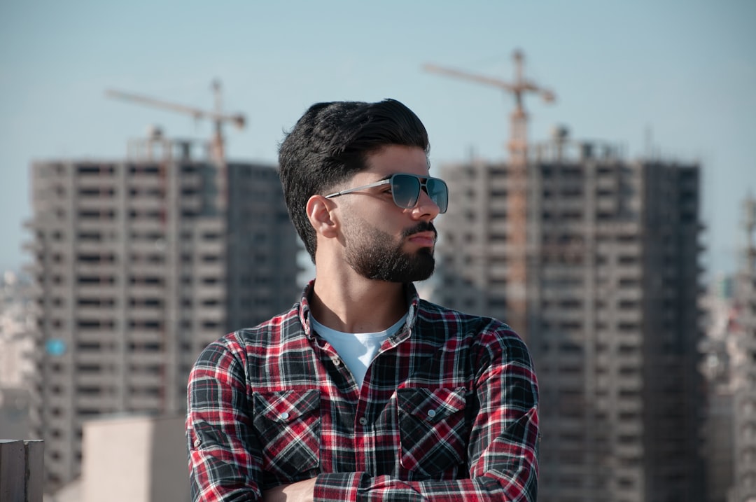 man in red white and blue plaid dress shirt wearing black sunglasses