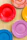 Close-up of a vibrant ceramic plate set arranged on a rustic wooden table.