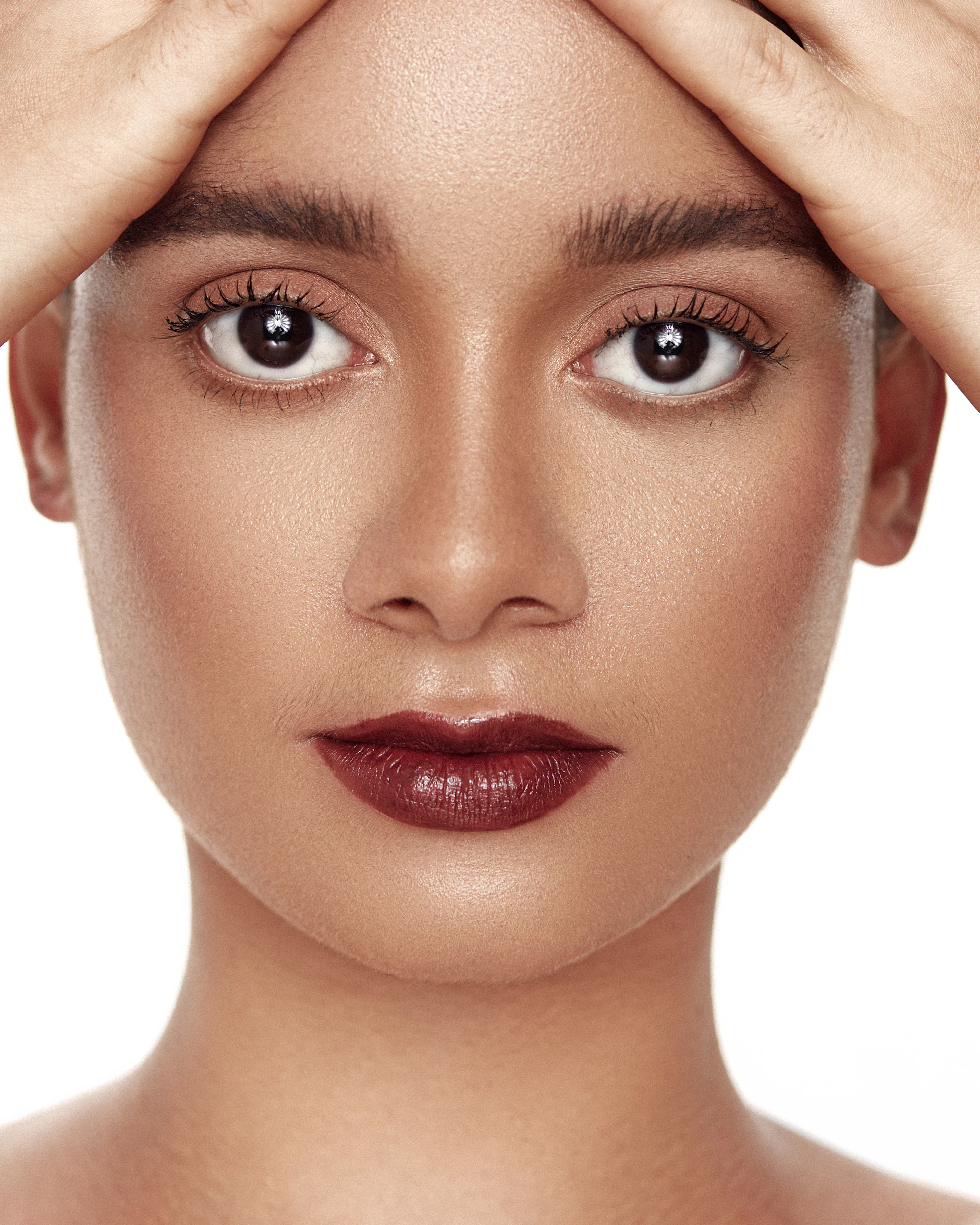 Symmetrical beauty portrait with defined brows and a berry lip