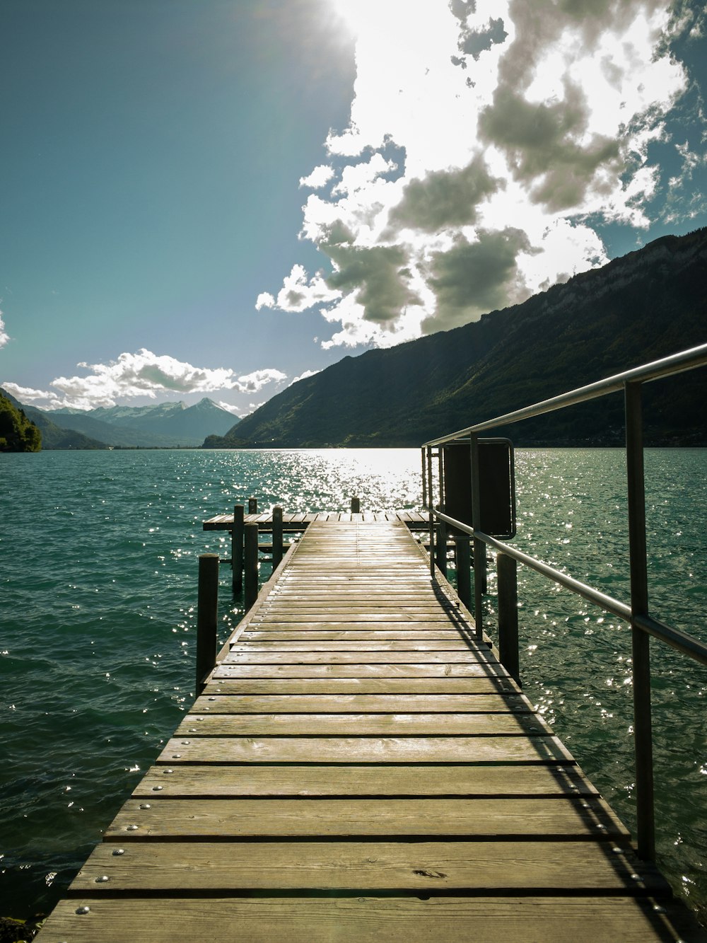 brown wooden dock on blue sea under white clouds and blue sky during daytime