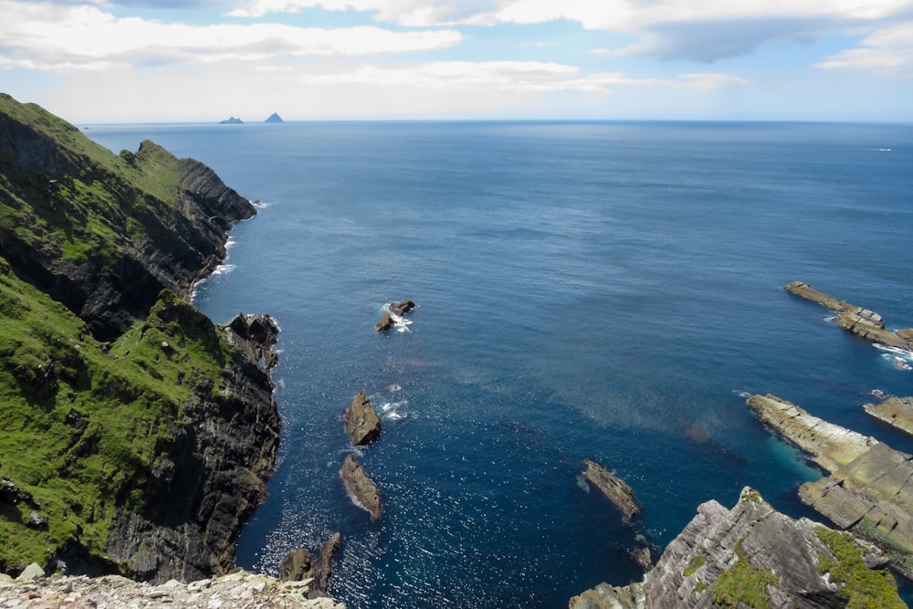 aerial view of green and brown mountain beside blue sea during daytime