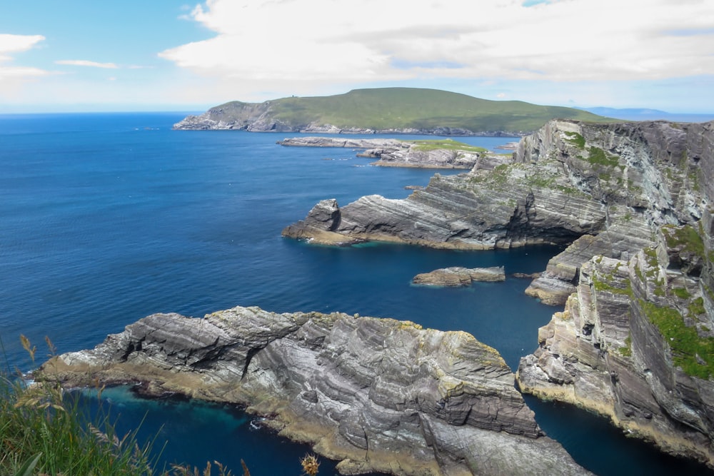 gray rock formation on body of water during daytime