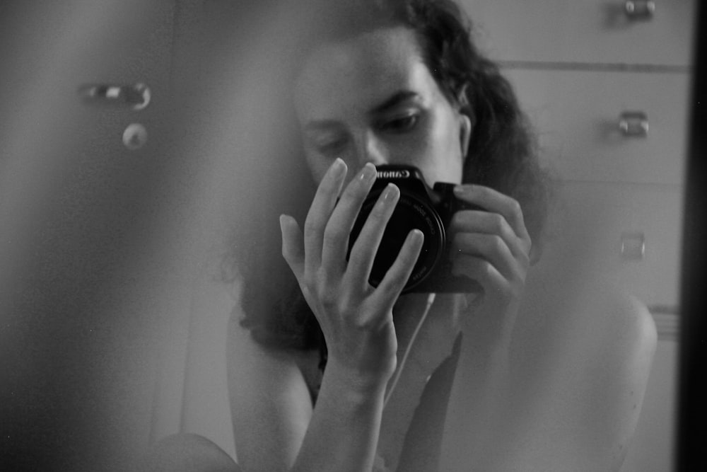 woman holding black dslr camera