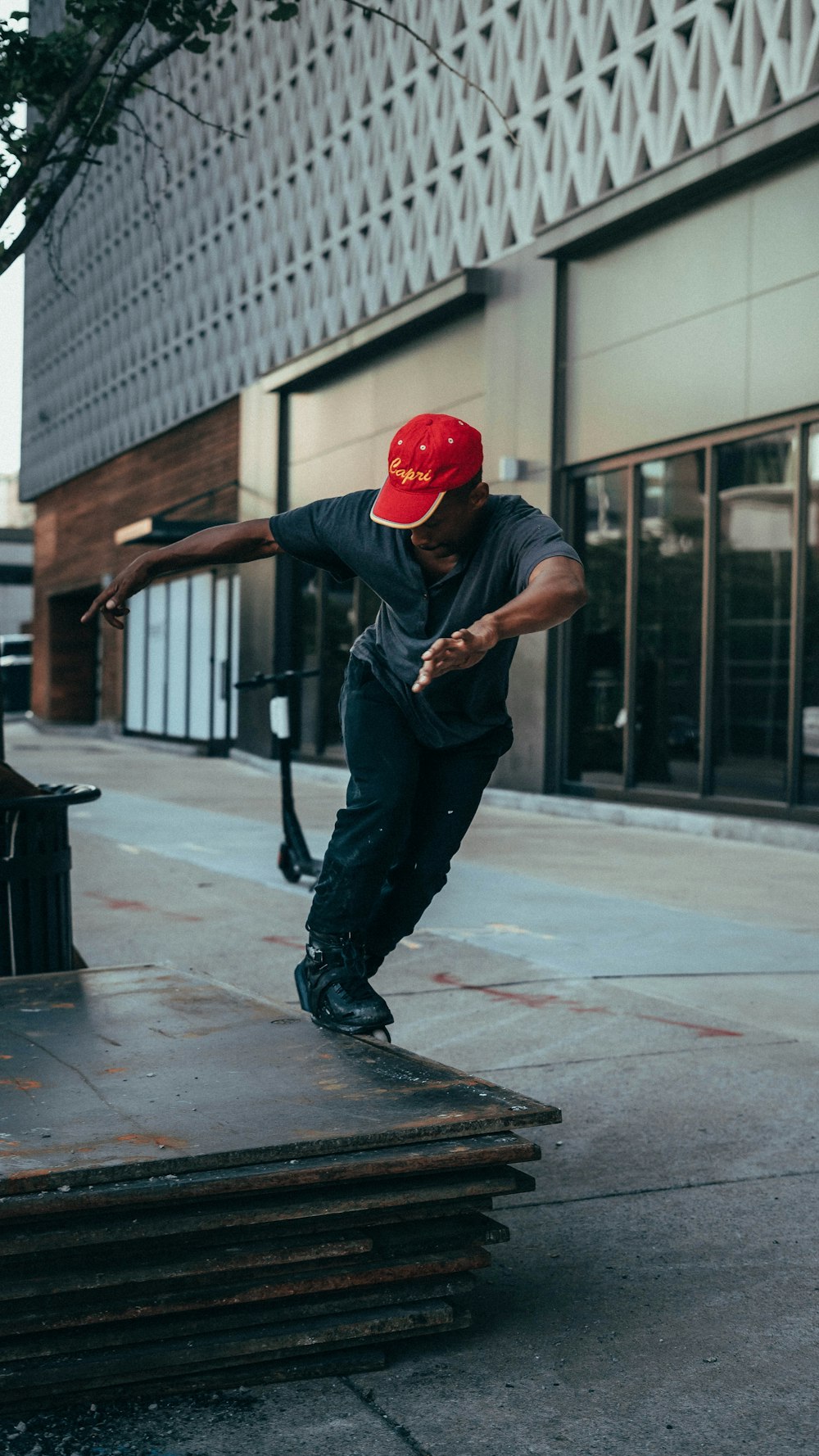 man in black jacket and red helmet walking on sidewalk during daytime