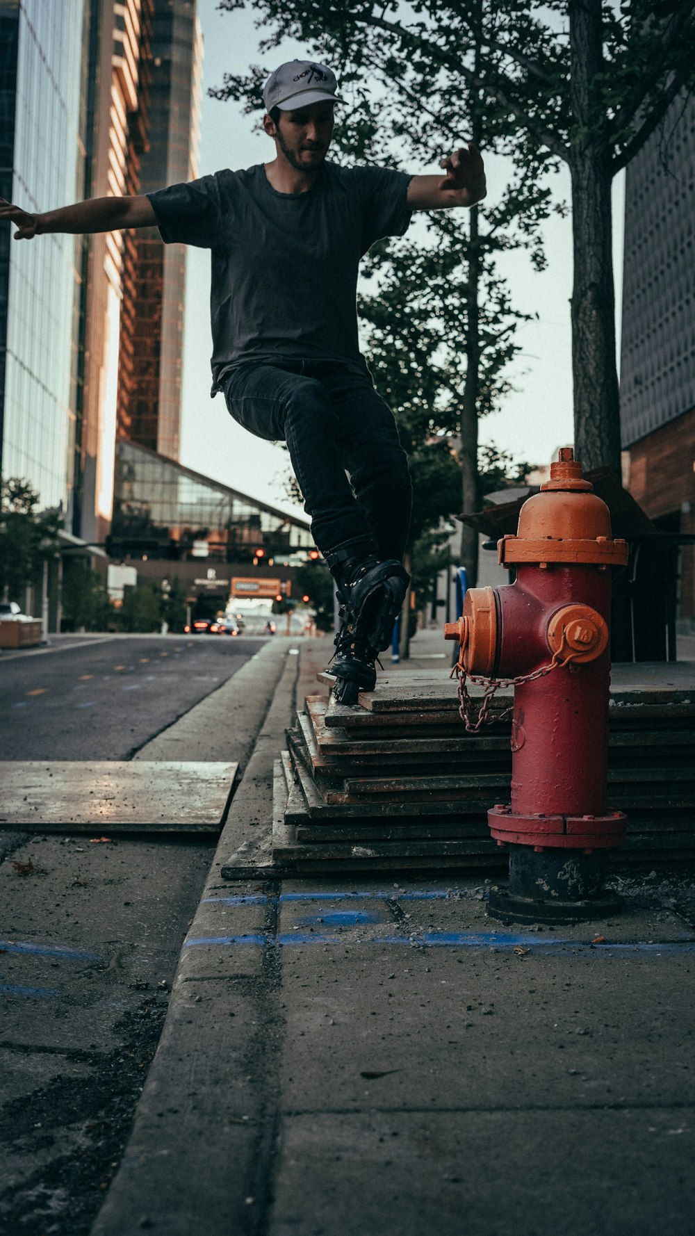 person in black pants and black jacket jumping on brown wooden bridge during daytime