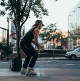 man in black tank top and black pants doing push up on sidewalk during daytime