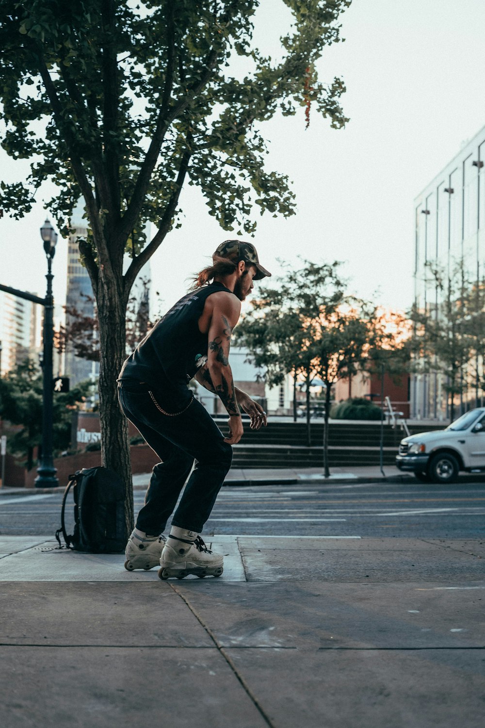 man in black tank top and black pants doing push up on sidewalk during daytime