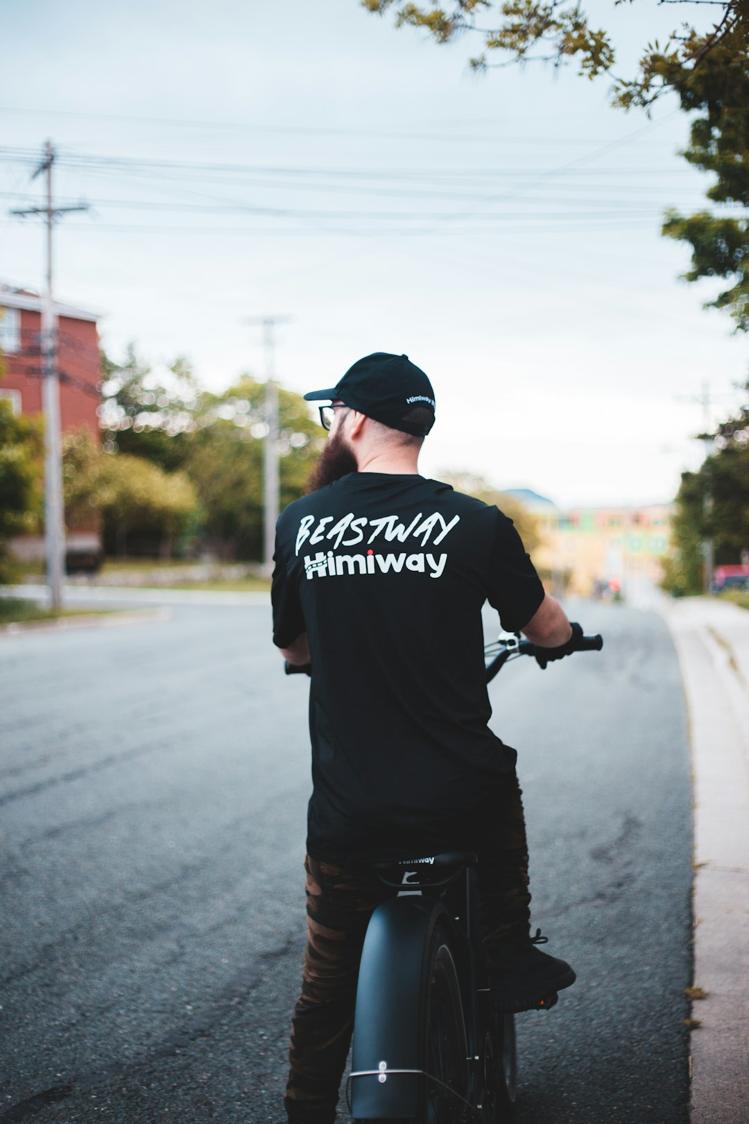 man in black and white crew neck t-shirt riding on black motorcycle during daytime